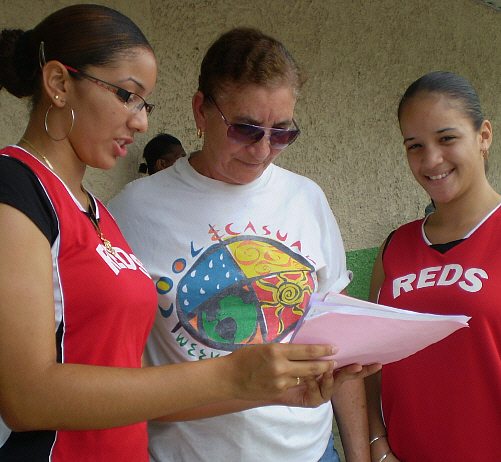 Volunteers Francheska Torres (left) and Rosanna Ascencio (right) explain the food donation drive to Margarita T. Morales.