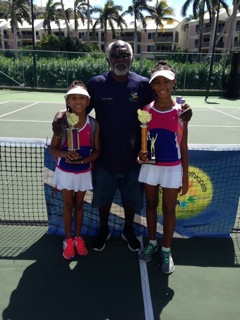 D’avian Lewis-Flynn, left, and Kishaundah Romain, right, with their tennis instructor Devon Peters after finishing second and first in their age brackets at the Junior Philanthropists Youth 4 Youth Tennis Tournament on St. Thomas