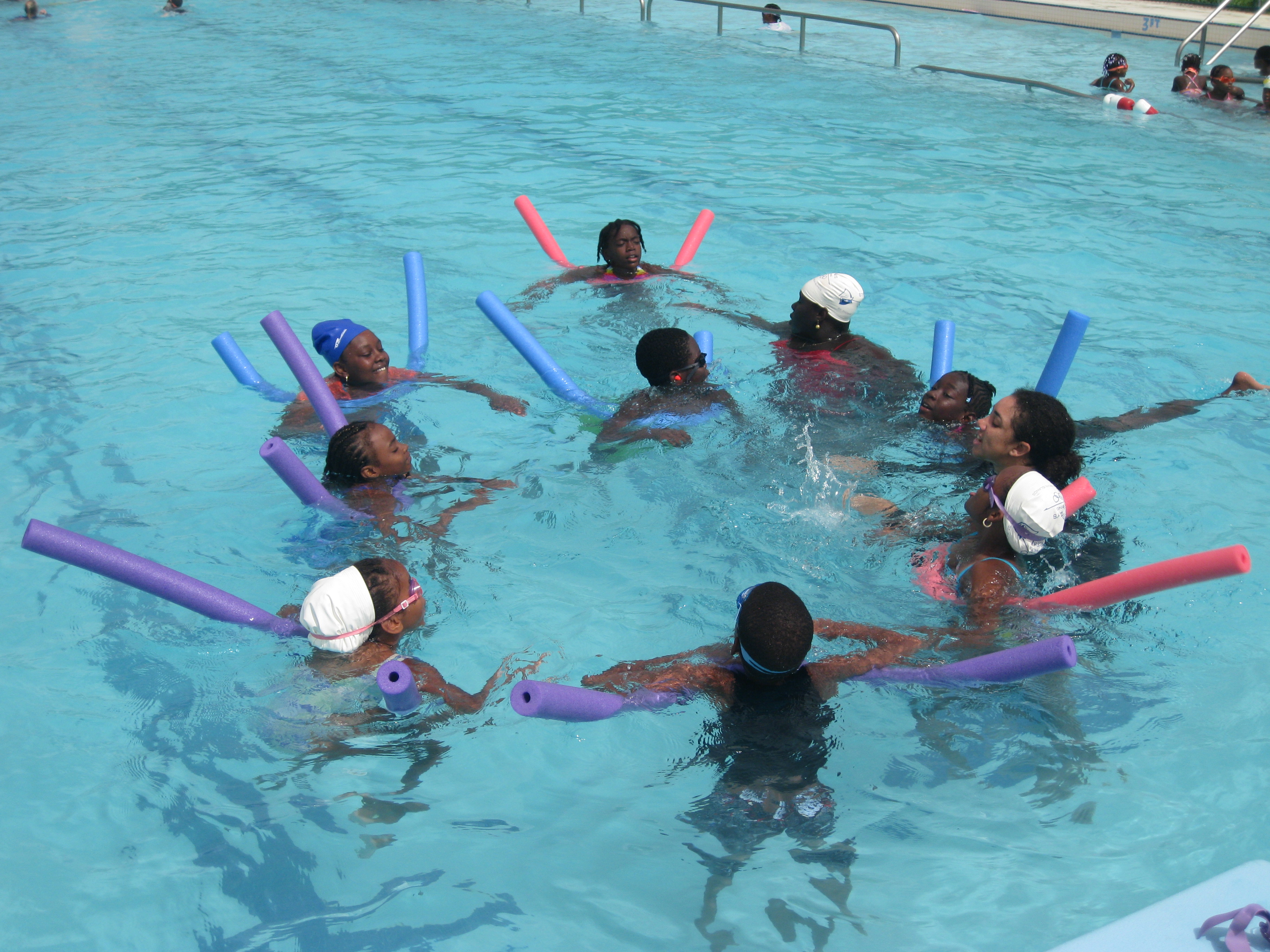 STSA swim instructor utilizes noodles to practice floating techniques in the water.