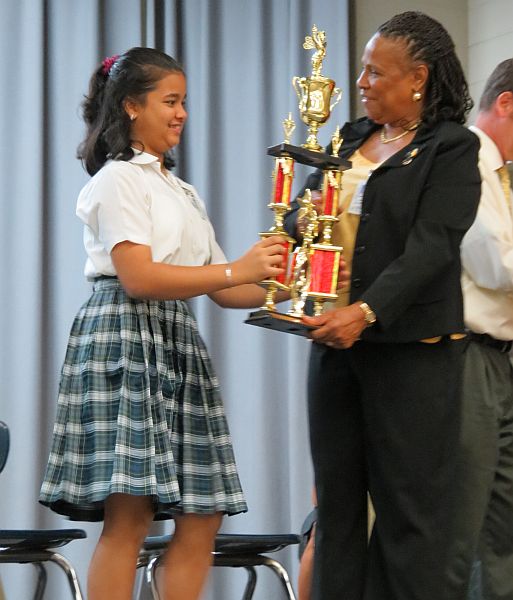   St. Thomas-St. John District Spelling Bee winner Roshni Lalwani accepts her trophy from District Superintendent of Schools Jeanette Smith-Barry.