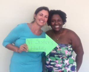 Sarah Haynes-Brin, left, and Nia Hazell, hold VI Sisters Huddle sign.