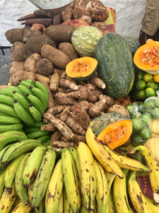 Locally grown quash, plantains and bananas fill a vendor’s colorful table.