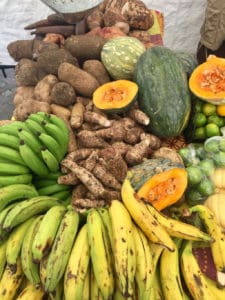 Locally grown quash, plantains and bananas fill a vendor’s colorful table. 