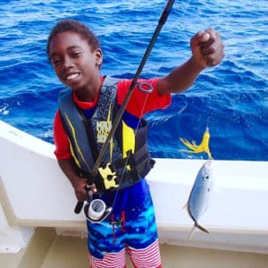     Joseph Wilson shows off his catch on a Marine Vocational Program outing. (Photo by Jimmy Loveland.)