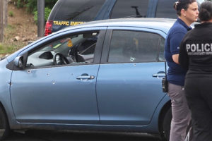 A bullet-riddled Toyota Yaris sits in the Ninky Center intersection after Thursday's shooting. 