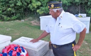 Comrade Eleuterio stands by the grave of veteran Enrique Quinones.