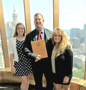 From left, Kaitlyn, Frank and Tammy Cummings display the award for his work at CORE at EPA's New York office.
