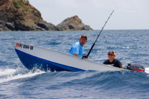 A pair of anglers make their way through the waves.