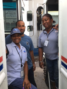 Postal workers, from left, Abigail Henry, K.C. Hodge and Terra Henry step out of their trucks.