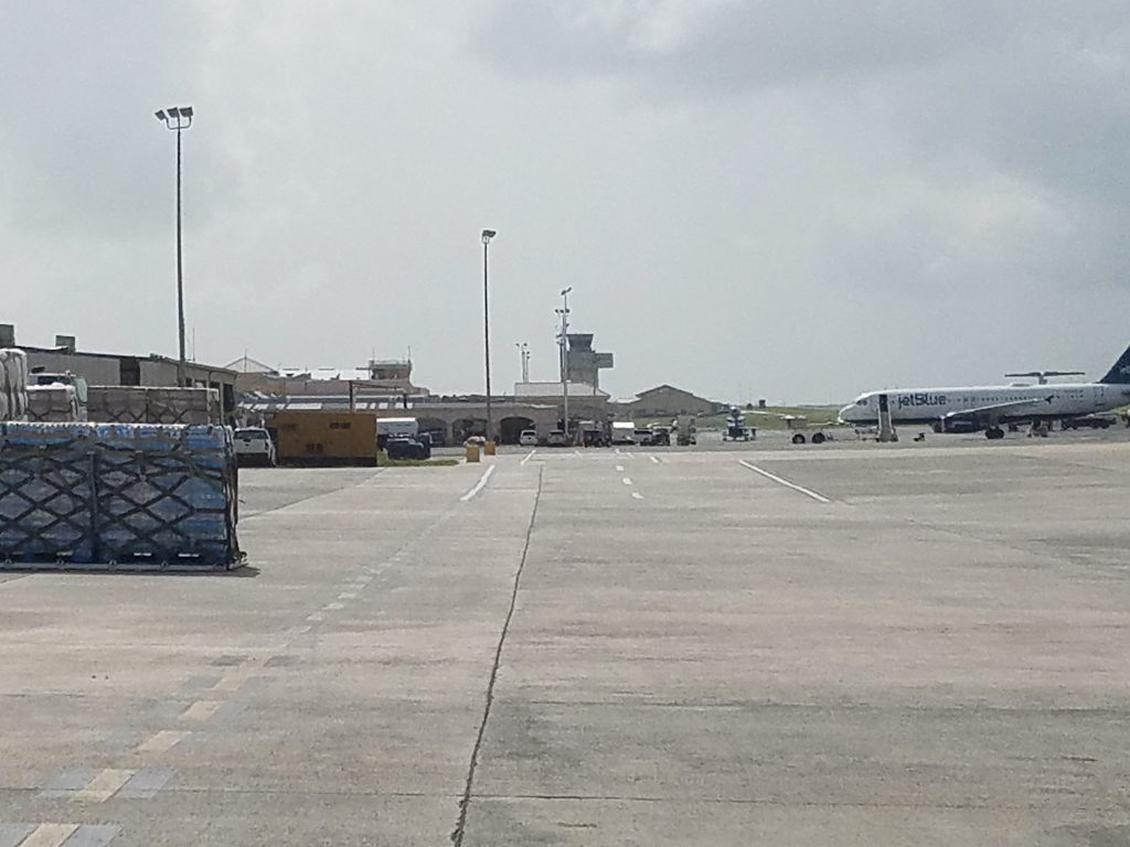 On the tarmac at Henry Rohlsen Airport, a Jet Blue mercy flight prepares to leave, while hurricane relief supplies are stacked in the foreground. (Jamie Leonard photo)