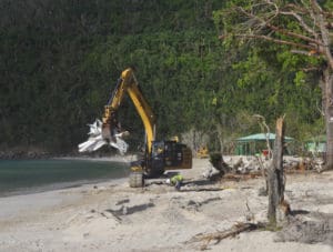 An earth-mover scoops up a load of debris at Magens Bay.