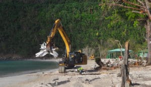 An earth-mover scoops up a load of debris at Magens Bay in October..