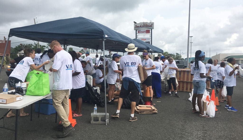 Volunteers hustle to hand out supplies and keep the line of cars moving quickly at Saturday's VI-R3 event.