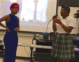 Keynote speaker Anamaat Kahina  listens to Chanel Mia Aubert, of the Seventh Day Adventist School.