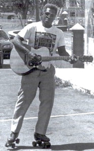 McIntosh plays guitar while roller skating in 1999 photo. (From McIntosh family)