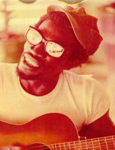 Sylvester 'Blinky' McIntosh plays guitar in family photo.