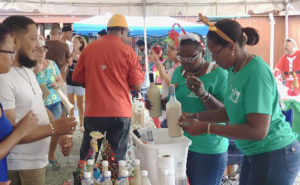 Tawana Nicholas and Jordan Albany pass out samples of coquito Saturday.