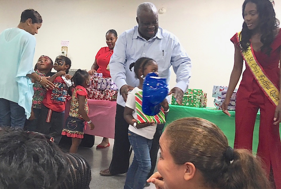 Gov. Kenneth Mapp distributes Christmas presents to children at the D.C. Canegata Recreation Center Wednesday.