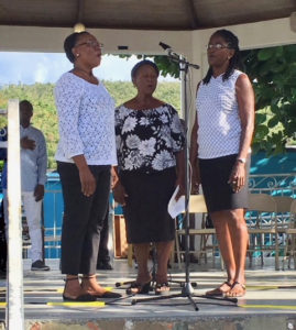 Faye Fredericks, Ruth Frett and Delrise Varlack sing the National Anthem.