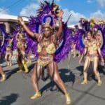 A colorful dance troupe marches down Fisher Street