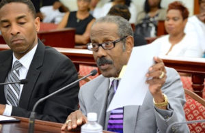 Dr. Alfred Heath, right, testifies before the Legislature in 2016, flanked by Attorney General Claude Walker. (File photo)