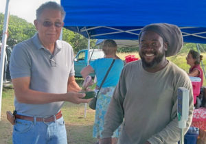 Grantley Samuel, right, sells fresh produce to Robert Schuster in this 2012 photo. (File photo)