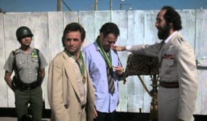 In a scene from 'The In-Laws,' corrupt Gen. Garcia of Tijada bestows medals on Peter Falk and Alan Arkin. Shortly afterwards he orders them executed. 