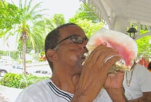 Steve Isaac of the Pan-African Support Group blows the conch shell on July 3, 2014. (Source file photo)