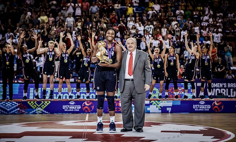 Aliyah Boston poses with the trophy after Team USA won the gold medal run at the 2018 U17 Women’s World Cup in Belarus. In the background, her teammates celebrate with their gold medals. (Photo by FIBA)