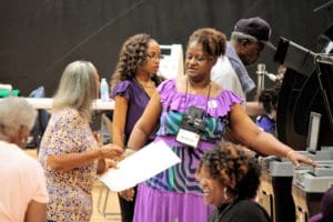 At UVI's Sports and Fitness Center, a poll worker for the Ulla Muller Elementary School polling site instructs a voter on how to use the DS200 tabulator.