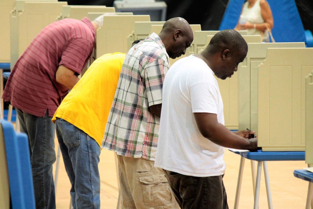 Voters fill in their ballots at the Gladys Abraham Elementary School Polling site inside UVI's Sports and Fitness Center.