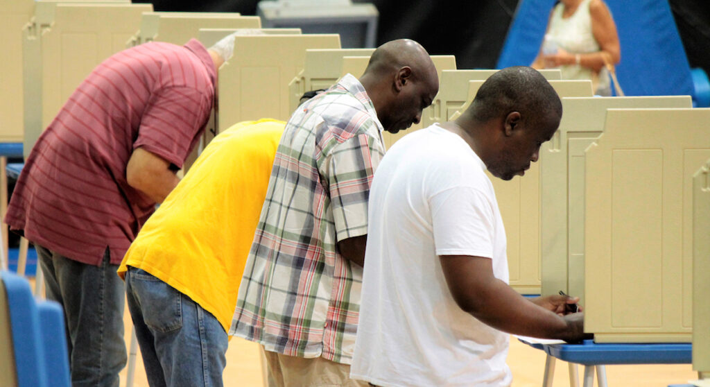 Voters fill in their ballots at the Gladys Abraham Elementary School Polling site inside UVI's Sports and Fitness Center.