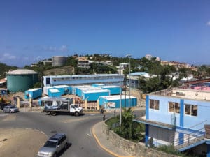 The blue modular units are being installed on the ballfield to replace the damaged classrooms at the Julius E. Sprauve School. One of the damaged building is in the right foreground.