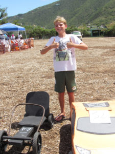 Henry Radcliffe, 11, shows off the go cart and cardboard 'Lamborghini' he built.