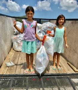 Sisters Isabel and Sofia Melendrez joined the crew Saturday as they bring in recyclable plastic.