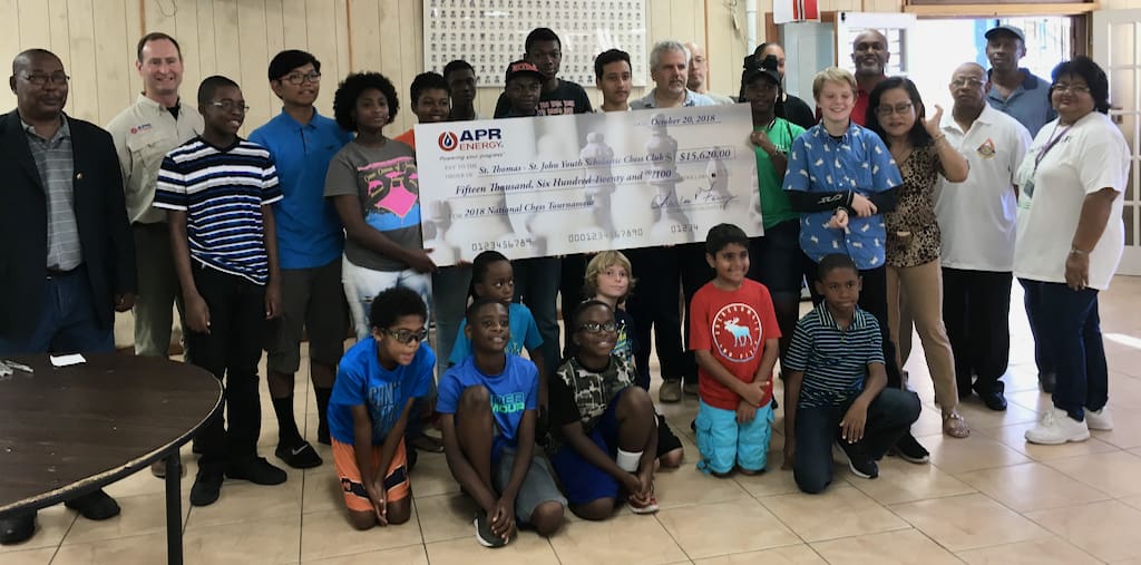 Members of the St. Thomas St. John Youth Scholastic Chess Club join officials of APR Energy and the V.I. Water and Power Authority during a check presentation ceremony Saturday at the Charlotte Amalie High School.