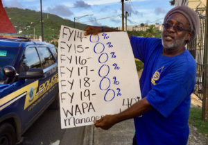 A WAPA employee's placard shows the zero percent raises he and his fellow workers have gotten in the last six years.