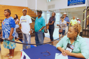 Polling Judge Donna Phillip, right, looks on as voters file into the UVI polling site.