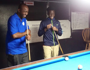 Billiards coach Jerome Anthony and champion Mahkeal Parris share a laugh as they talk strategy.