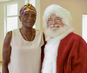 Senior resident Mary Edwards, 81, takes a picture with Santa.