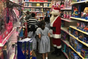 Santa Claus escorts students through the toy section.