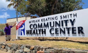 Schneider VP of Facilities Management Darryl Smalls puts on an 'open' sign on the Myrah Keating Smith marquee on St. John.