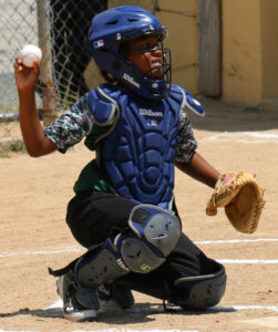 Omar Budhoo, catcher for the Spartans, throws the ball back to the pitcher as the first game of the new season starts. (Linda Morland photo)