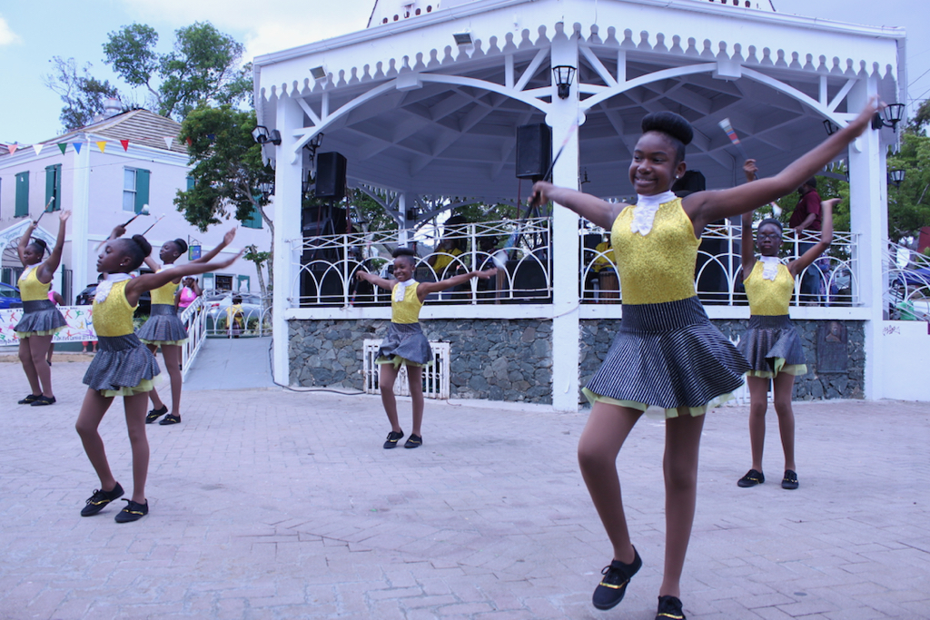 Intermediate skilled students of St. Thomas Majorettes, a nonprofit organization teaching students baton twirlingwho, sparkle in gold and black outfits while performing their routine. (Bethaney Lee photo)