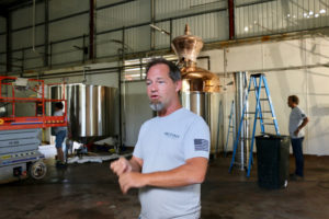 Todd Manley, co-founder of Sion Farms Distillery, stands amid the hustle and bustle of the equipment being installed in the facility. (Linda Morland photo)