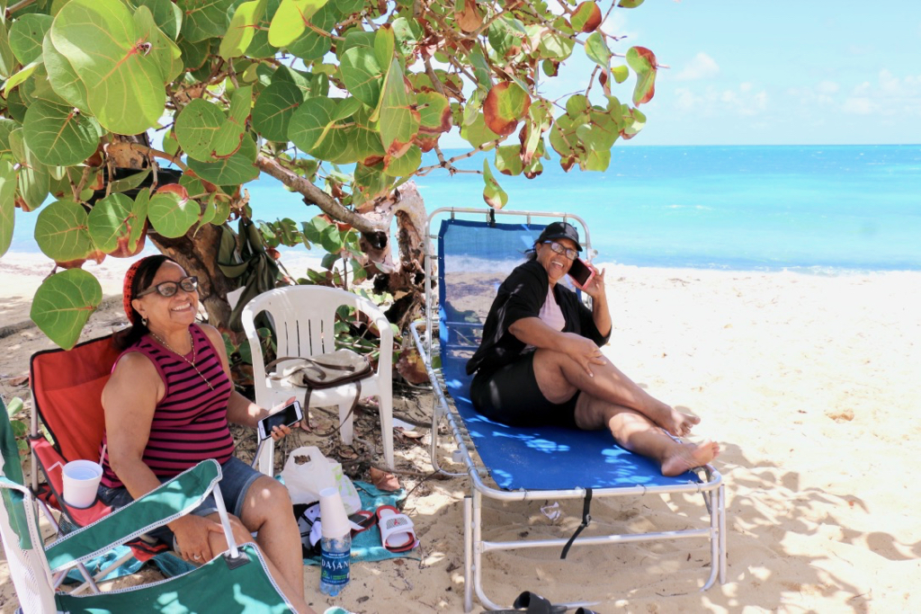 On the beach at Little Bay, Rudidenia Reye and Francia Espinal relax as they wait for family and friends to join them for the afternoon. (Linda Morland photo)
