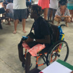 Wheelchair bound Fillemon Waikuwile receives his award.