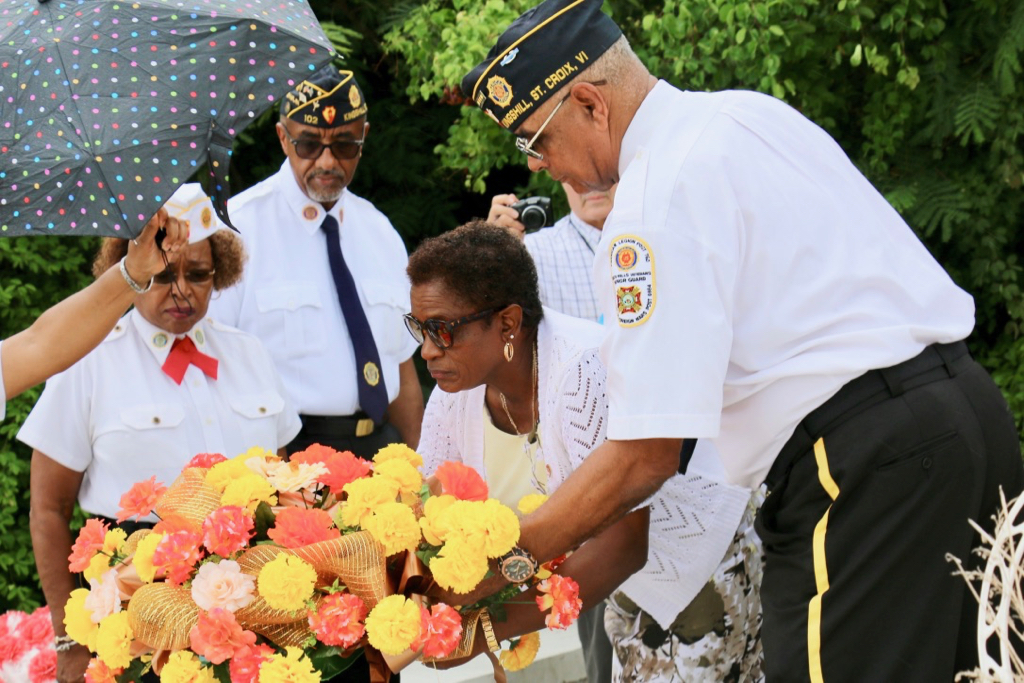 Ana Hernandez McIntosh places a wreath in honor of her husband, Gleston McIntosh and in remembrance all other veterans who have died. (Linda Morland photo)