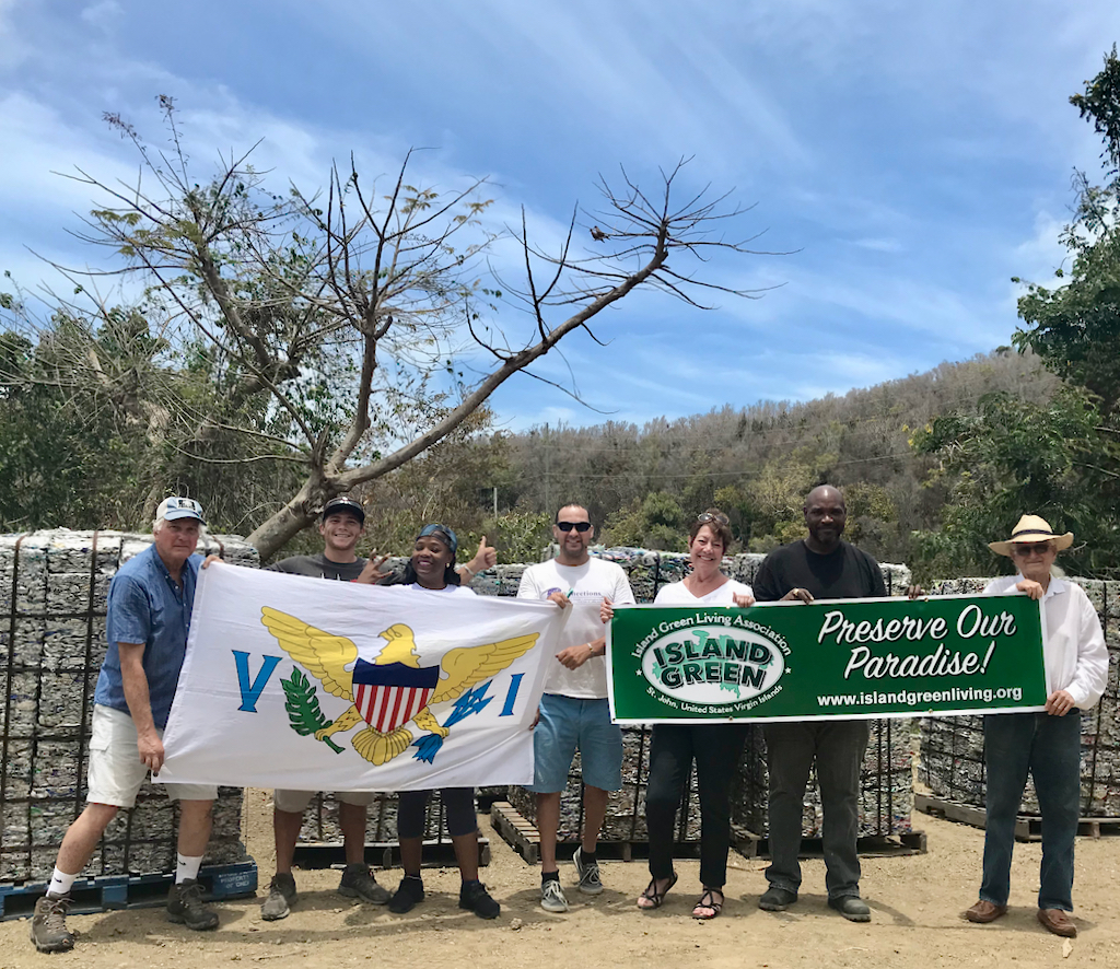 From left, Jim Kriner, Anthony Novelli, Shikima Jones, Jason Daoust, Cid Hamling, Michael Marsh and Doug White raise a banner to celebrate aluminum can recycling. (Photo provided by Doug White)