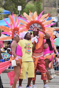 Arah Lockhart, left, and Sen. Kenneth Gittens, right, talk with radio personality George Silcott the details about Elskoe and Associates’ parade entry. (Photo provided by V.I. Carnival Committee)